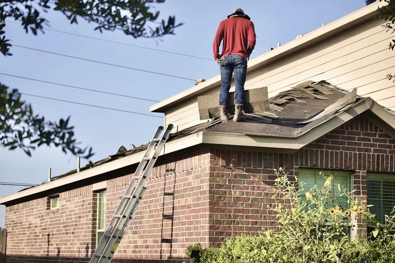 Professional roofer working on a residential roof in Lee School
